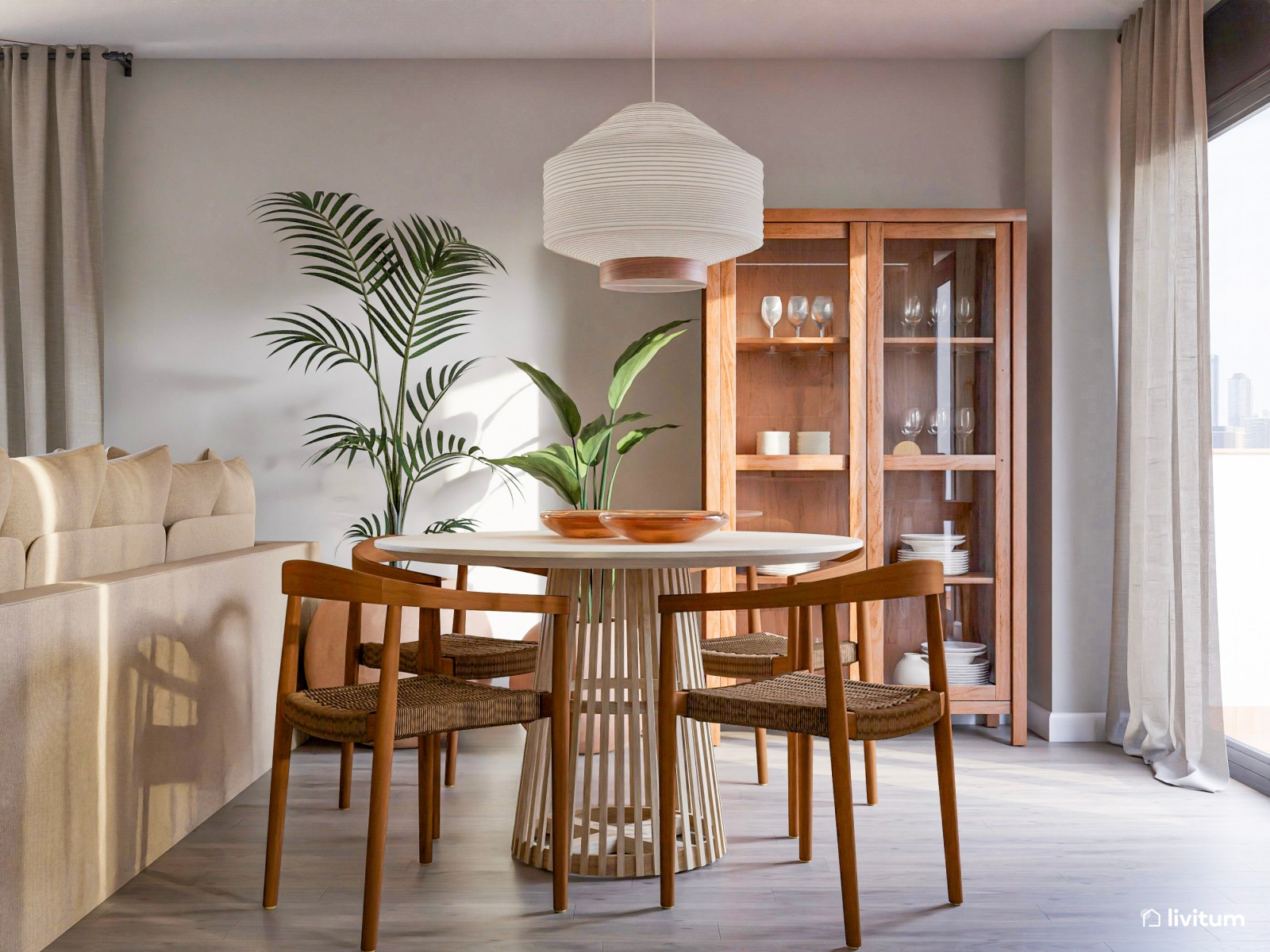 Acogedor salón con comedor redondo, cocina abierta y plantas decorativas