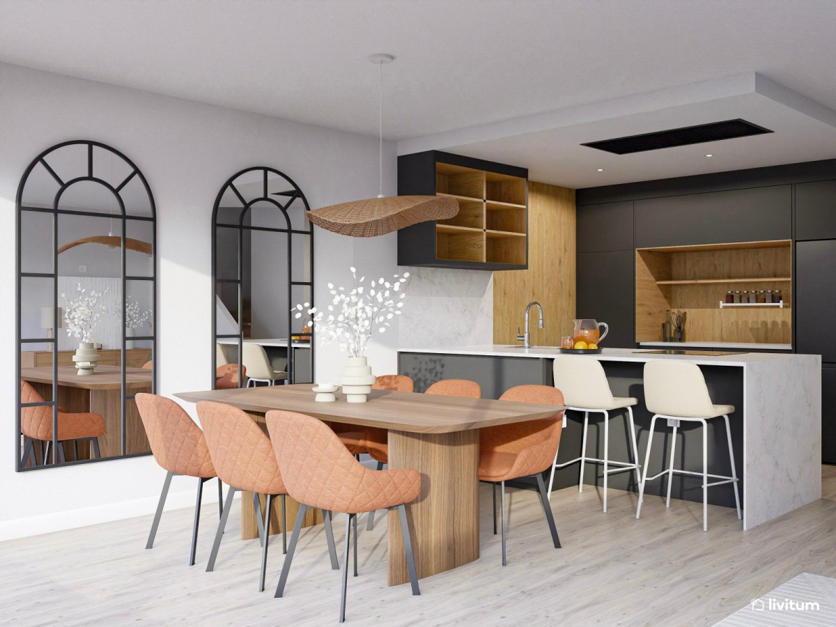 comedor con cocina abierta en m&aacute;rmol negro y mesa de comedor de madera oscura con sillas naranjas