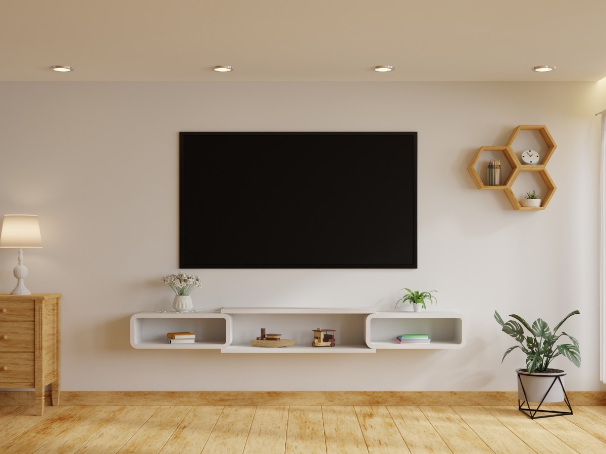 sal&oacute;n con pared blanca y suelo en madera con tv colgada